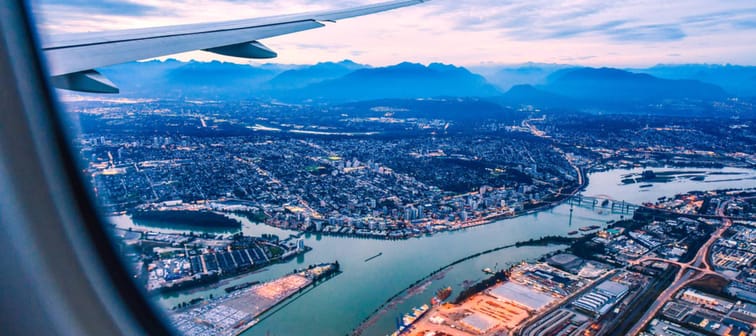 View from airplane window on fields in wing with top view of Vancouver