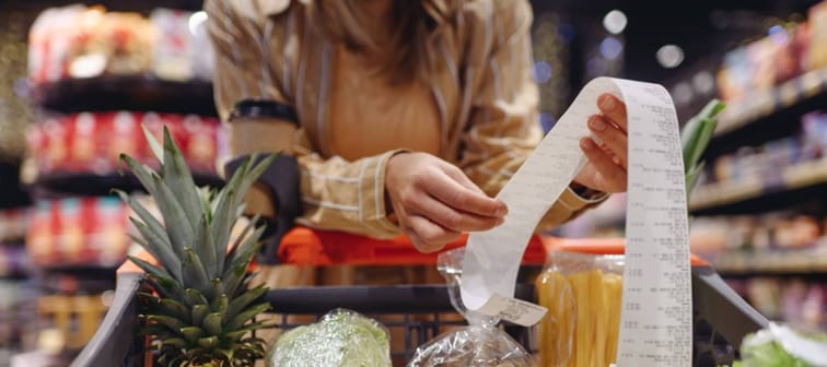 Woman holding long grocery receipt
