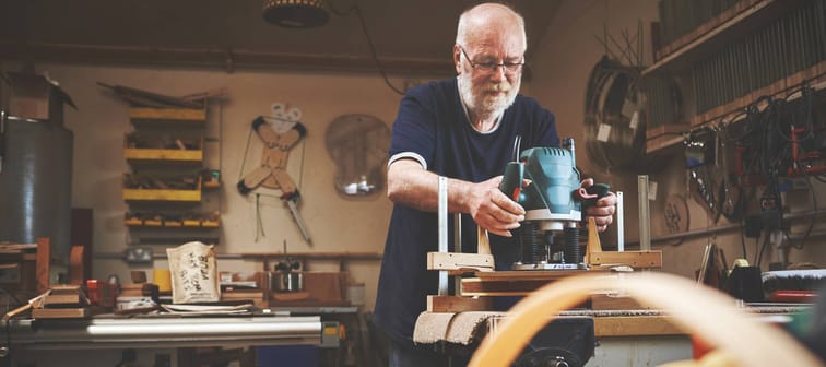 Senior man using woodworking tools.