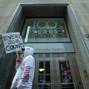 A protestor walks past the main doors of Toronto Hydro prior to impending layoffs. Feb 27, 2012.