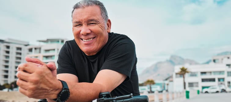 Man smiling eaning on his bike